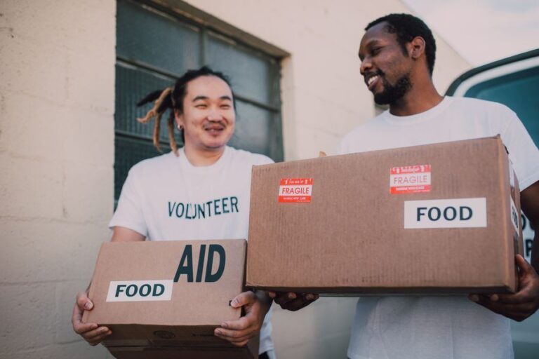 Volunteers carrying boxes of food to share